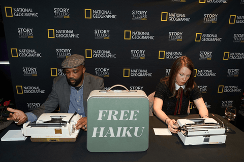 Two poets writing haiku on typewriters at National Geographic event