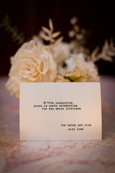 Haiku on a wedding table with white flowers in the background